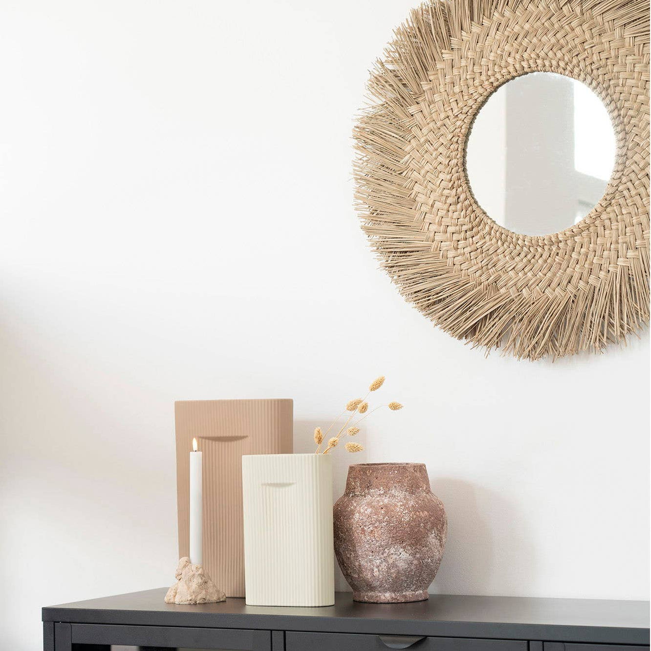 Deko Vase in Braun auf einem Tisch mit skandinavischem Stil und einem runden Spiegel im Hintergrund.